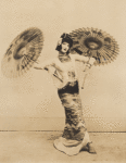 Doris Humphrey in oriental costume holding parasols 