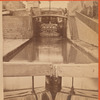 View of locks, showing a boat locking through, Lockport, N.Y.