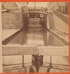 View of locks, showing a boat locking through, Lockport, N.Y.