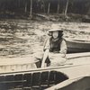 Young woman in canoe wearing hat