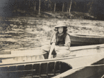 Young woman in canoe wearing hat