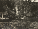 Four figures in a canoe on the water