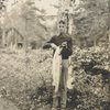 Frederick V. Field holding a fish in the woods