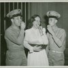 Woman with service men eating cookies