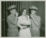 Woman with service men eating cookies