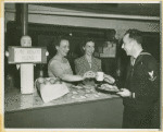 "One Dessert Please!" - Hostesses giving sailor coffee and fruit.