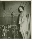 Woman on stage performing for service man at Stage Door Canteen.