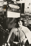 Entertainer and nightclub owner Ada "Bricktop" Smith posing next to sign outside her club, Paris, France