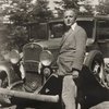 Henry Cowell standing in front of a car