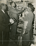 John Harmon with two unidentified customers at grocery store