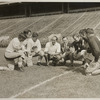 Ted Husing surrounded by football players
