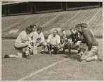 Ted Husing surrounded by football players
