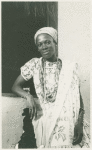 Women wearing beaded necklaces, posing with elbow on ledge