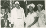 Man and two women, four men visible in background