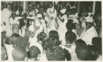 View of ceremony showing participants, drummers and onlookers in foreground and background