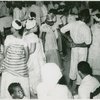 View of attendees at ceremony, showing a woman seated at left and a man seated in foreground, right