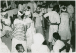View of attendees at ceremony, showing a woman seated at left and a man seated in foreground, right