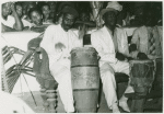 Close-up of two drummers with onlookers in the background