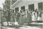 Several women and one man outside of a religious house
