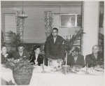 Carlton Moss (standing) addressing armed forces servicemen and women at annual Thanksgiving Dinner