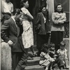 Group of men, women and children gathered on stoop, East Harlem, New York City