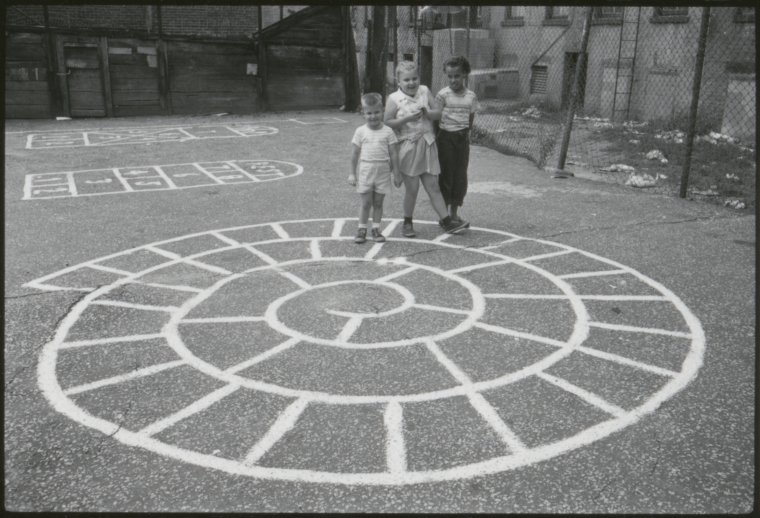 Black-and-white photo of three children on a playground