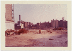 Exterior location: rubble strewn lot, city buildings in the distance