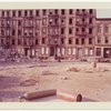 Exterior location: another rubble strewn lot, row of vacant tenements across the street in the background