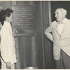 Katherine Hepburn and Lawrence Langner standing between plaque honoring Langner in lobby of the American Shakespeare Festival