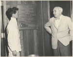 Katherine Hepburn and Lawrence Langner standing between plaque honoring Langner in lobby of the American Shakespeare Festival