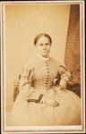 Studio portrait of unidentified seated woman wearing check dress.