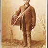 Studio portrait of man holding box labelled 'Confectionery'