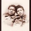 Studio portrait of two young women, heads touching.