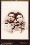 Studio portrait of two young women, heads touching.
