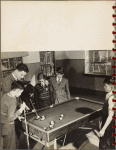 man teaching boys to play billiards
