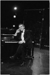 Joseph Papp sitting at piano with cigar in hand, December, 1986.