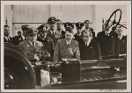 The high point of the International Automobile and Motorcycle show in Berlin was the inspection of the KdF-Car by the Fuhrer.  At the Fuhrer's left is Dr. Ley, while Dr. Porsche, technical designer of the Volkswagen, is to his right