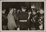 In these days, Italian combat veterans visited Germany.  Our picture shows the Fuhrer talking to his guests at the Fuhrerbau in Munich.  To the right of the Fuhrer is the blinded President Delcroix.