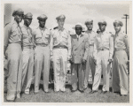 Tuskegee officers posing with their base commander Noel F. Parrish (4th from left) and unidentified man