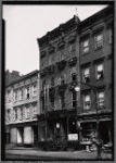 [Wooden row houses and storefronts; Home of Satisfaction Cleaning: 33 [street unknown], Manhattan]