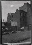 Demotion site with Slum Clearance sign and street diggers working: Manhattan