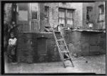 Rear of tenements with young boy: Manhattan