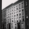 Tenements under renovation; workers outside