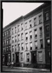 Tenements under renovation; workers outside