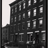 Residents posed at tenement windows and on stoop