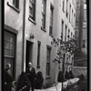 Tenement House Inspector posed in front of building entrance