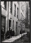 Tenement House Inspector posed in front of building entrance