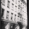 Tenement House Inspector posed in front of vacant storefronts: Manhattan