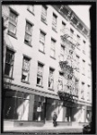 Tenement House Inspector posed in front of vacant storefronts: Manhattan