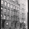 Tenements and storefront; horse and wagon: Manhattan